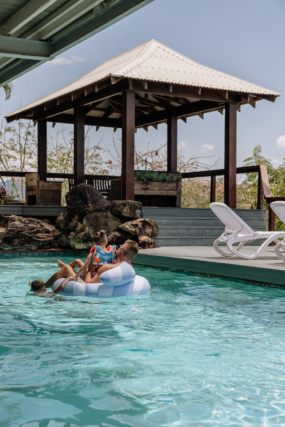 Family enjoying the pool beneath the gazebo